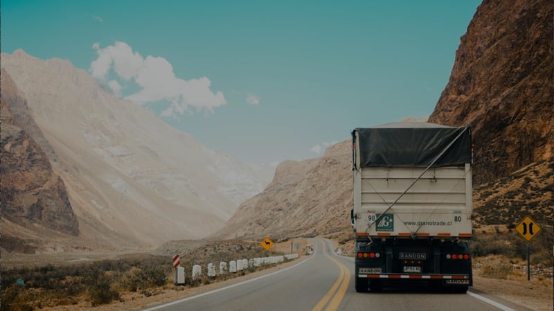 Lkw auf einer kurvigen Bergstraße in einer kargen Landschaft