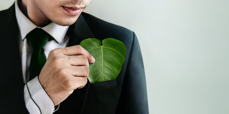 Ein Business Man steckt sich ein Blatt in den Anzug