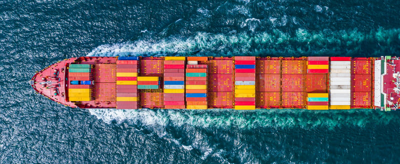 Ein Frachtschiff mit einigen Frachtcontainern darauf auf dem Meer