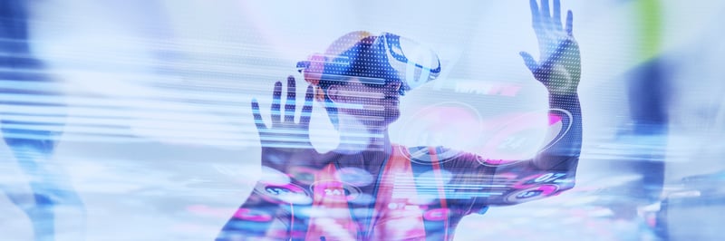 Ein Mann mit orangener Weste und VR-Brille interagiert mit einer digitalen Wand
