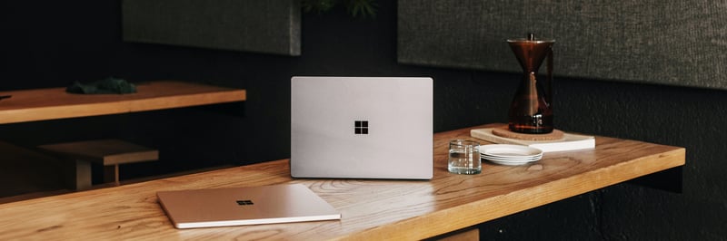 Ein Microsoft Laptop steht auf einem Tisch, daneben liegt ein zweites.