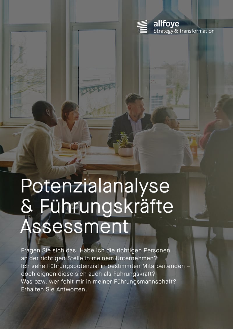 Ein Team sitzt gemeinsam an einem Tisch und arbeitet in entspannter Atmosphäre.