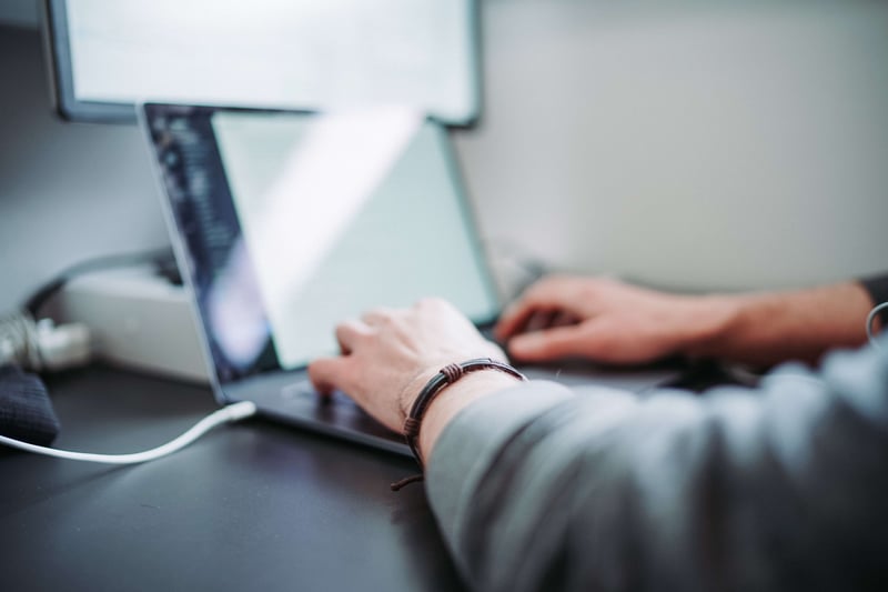 Hände eines Mannes auf Laptop-Tastatur