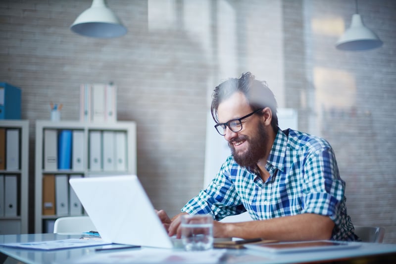 Mann an Schreibtisch arbeitet am Laptop