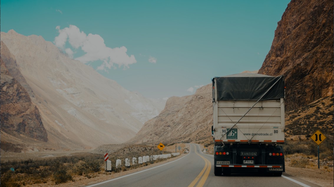 Lkw auf einer kurvigen Bergstraße in einer kargen Landschaft